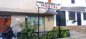um sinal em frente a uma casa com um hospital em Hostal Perlaschallay em Ayacucho