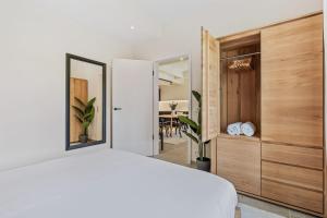 Schlafzimmer mit einem weißen Bett und einem Spiegel in der Unterkunft Clausen Hideaway Modern Accommodation in Luxemburg (Stadt)
