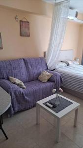 ネルハにあるEstudio Complejo Andaluciaの紫色のソファとベッド付きのリビングルーム