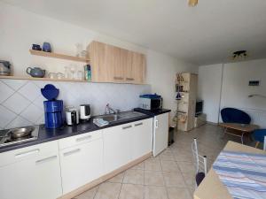 eine Küche mit weißen Schränken und einer Arbeitsplatte in der Unterkunft Ferienquartier Müller Z4 in Zinnowitz + 2 Fotos