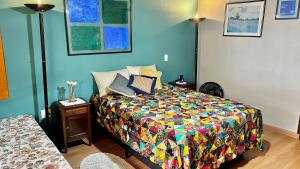 um quarto com uma cama com um edredão colorido em Suite de casa de campo em Socorro