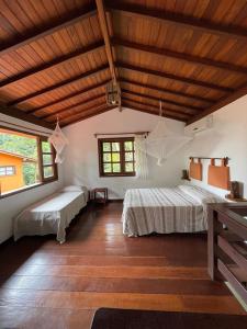 1 dormitorio con 2 camas y techo de madera en Vila Sofia chalès, en Morro de São Paulo