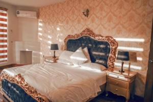 Zavyan Cottage 1 في Nathia Gali: غرفة نوم بسرير كبير مع اللوح الأمامي الأزرق والأبيض
