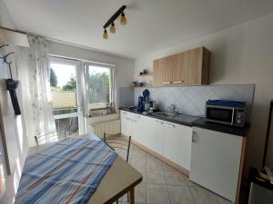 eine Küche mit einer Spüle und einer Mikrowelle auf der Theke in der Unterkunft Ferienquartier Müller Z4 in Zinnowitz