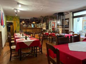 a restaurant with tables and chairs with red tablecloths at Hotel El Refugio de Juanar in Ojén