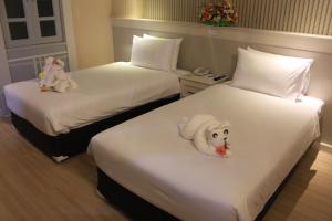 Postel nebo postele na pokoji v ubytování โรงแรมวีวิช V Wish Hotel