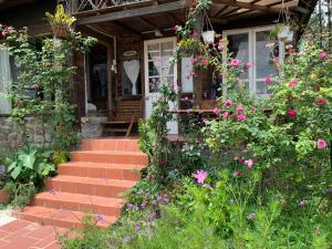 Ein Haus mit einem Blumenstrauß auf der Veranda. in der Unterkunft Romantic house on a pine hill Dalat in Xuan An