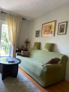 a bedroom with a green couch and a table at Holiday home Gudelj in Imotski