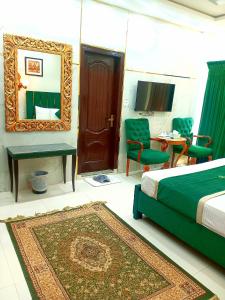1 dormitorio con cama, espejo y mesa en Golden One Hotel, en Lahore