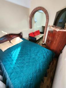 1 dormitorio con cama azul y espejo en Hospedaje Chavez, en La Paz