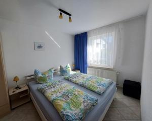 ein Schlafzimmer mit einem Bett und einem Fenster mit blauen Vorhängen in der Unterkunft Ferienquartier Müller Z4 in Zinnowitz