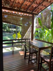 a wooden deck with benches and a table at Vila Sofia chalès in Morro de São Paulo
