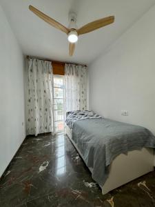 Un dormitorio con una cama y un ventilador de techo. en Vista & Calma Castell de Ferro, en Castell de Ferro