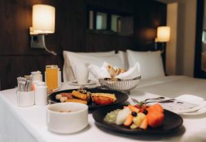 a table with two plates of food on a bed at Holiday Inn Abu Dhabi by IHG in Abu Dhabi