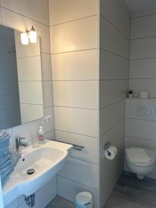 bagno bianco con lavandino e servizi igienici di Seelord 53 (Meloh) a Norderney