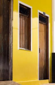 um edifício amarelo com duas janelas e uma porta em Pousada Nativos Lençois em Lençóis