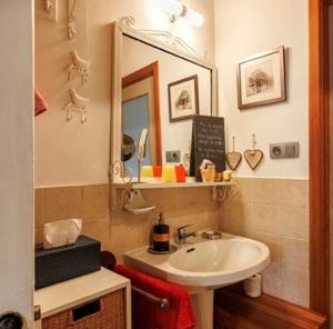 uma casa de banho com um lavatório e um espelho em Maison et son jardin situés dans le Condroz em Marchin