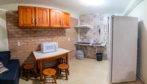 uma cozinha com um frigorífico e uma mesa com um micro-ondas em Pousada Nativos Lençois em Lençóis