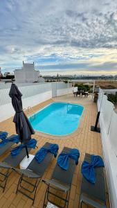 un patio avec des chaises et une piscine sur le toit dans l'établissement Casa "Vento" Ferragudo mit privatem Pool, à Ferragudo