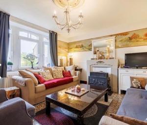 uma sala de estar com um sofá e uma lareira em Maison et son jardin situés dans le Condroz em Marchin