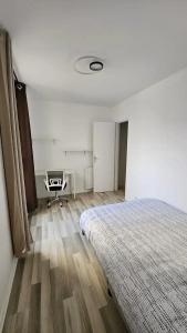 um quarto com uma cama e uma cadeira em Ruby room - 20 min to Paris em Créteil