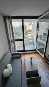 uma sala de estar com um sofá e uma mesa em Ruby room - 20 min to Paris em Créteil