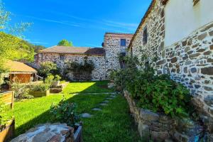 a backyard of a house with a stone wall at La Maison De Pierre in Langeac