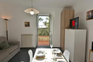 a living room with a table and a white refrigerator at Welcome Varigotti - Civico53 in Varigotti