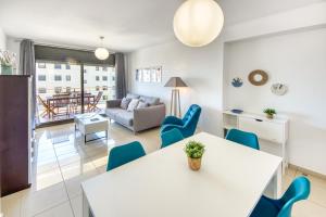 sala de estar con mesa blanca y sillas azules en Mileni 2 1 3 1 Roses - Immo Barneda, en Roses