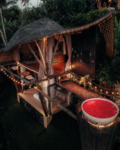 Selat的住宿－Camaya Bali - Magical Bamboo Houses，前面有一个红色碗的小小屋