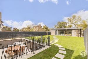 einen Hinterhof mit einem Pool und einem Zaun in der Unterkunft Le Jardin De Marie in Pontorson
