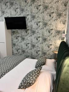 1 dormitorio con cama y pared con papel pintado en Costantino Home, en Pompeya
