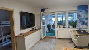 a living room with a television and a table and chairs at Kaufbeuren mit Wintergarten in Kaufbeuren