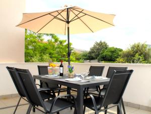 a table with a yellow umbrella on a patio at Family apartments Jimmy - city center in Pag