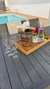 - un plateau avec des verres à vin et un seau sur une table au bord de la piscine dans l'établissement Casa "Vento" Ferragudo mit privatem Pool, à Ferragudo
