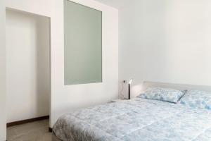 Un dormitorio blanco con una cama y un espejo. en Caval D'Or, en Como