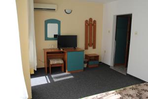 Habitación con escritorio y TV. en Guest House Elit en Burgas