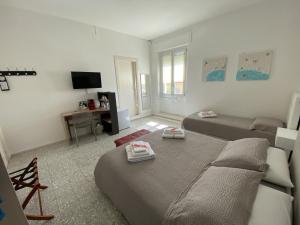 uma sala de estar com duas camas e uma televisão em Rossocorallo Rooms em Alghero