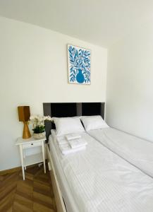 a white bed in a room with a side table at Ogarna 33 studios in Gdańsk