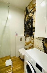 a bathroom with a toilet and a washing machine at Ogarna 33 studios in Gdańsk +13 photos