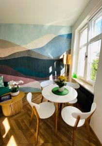 a room with two tables and chairs and a mural at Ogarna 33 studios in Gdańsk