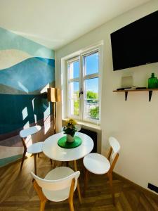 a living room with a table and chairs and a tv at Ogarna 33 studios in Gdańsk