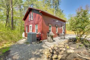 a red cabin in the woods with a yard at UpdatedandPet-Friendly Cabin By Hikes and Woodstock! in Bearsville