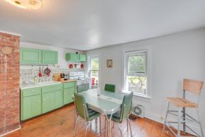 een keuken met groene kasten en een tafel en stoelen bij UpdatedandPet-Friendly Cabin By Hikes and Woodstock! in Bearsville