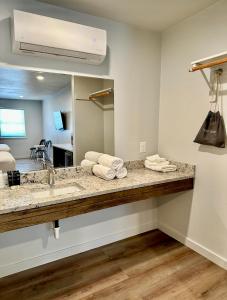 La salle de bains est pourvue d'un lavabo et d'un miroir. dans l'établissement Lakeside Motel, Cabins and RV, à Kingston