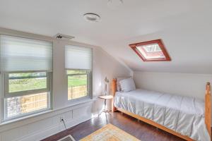 1 dormitorio con 1 cama y 2 ventanas en UpdatedandPet-Friendly Cabin By Hikes and Woodstock!, en Bearsville