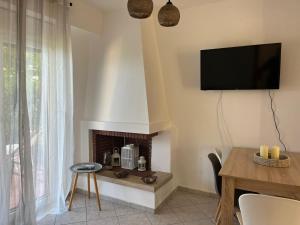 a living room with a fireplace and a tv on the wall at Nikogroup By the Sea 2 in Polychrono