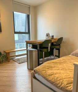 a bedroom with a desk and a table and a bed at Luxury studio with balcony in Reykjavík