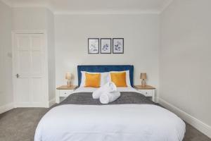 1 dormitorio con 1 cama blanca grande con almohadas de color naranja en Charming 2-Bedroom House in Darlington en Darlington