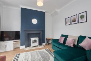 sala de estar con sofá verde y chimenea en Charming 2-Bedroom House in Darlington en Darlington